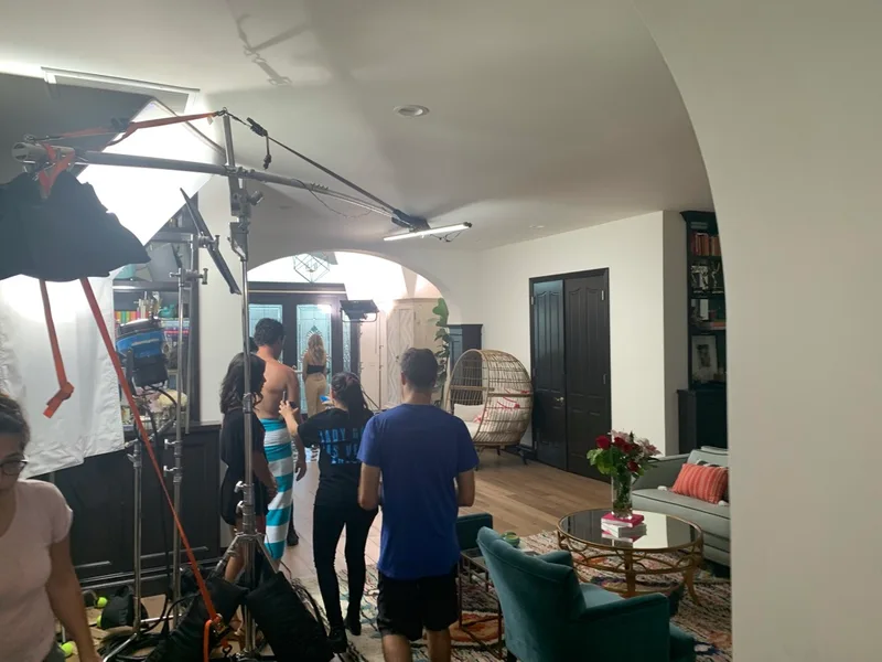 Crew, lighting and boom microphone on a living-room set